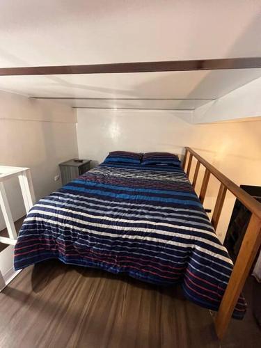 Cette chambre comprend un lit avec une couverture bleue et blanche. dans l'établissement Casa colonial Rosa San Antonio, à Cali