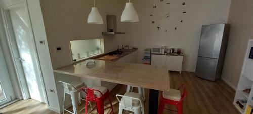 a kitchen with a wooden table and red chairs at Ginny's Room in Quartu SantʼElena