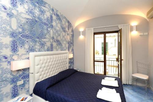 - une chambre avec un lit bleu et un mur bleu et blanc dans l'établissement La Casa ad Amalfi centro storico, à Amalfi