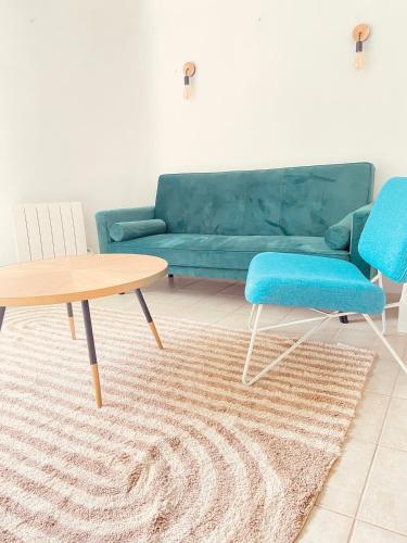 a living room with a couch and a table and chairs at Maison le havre des marées in Cabourg