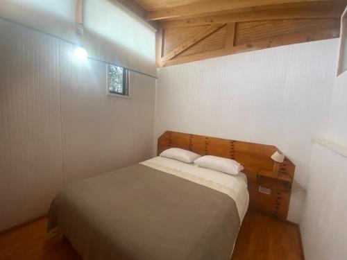 a small bedroom with a bed and a window at Hotel Costa Pichidangui in Pichidangui