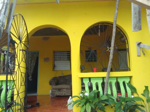 a yellow house with a dog laying on a couch at Eden Palace in Montego Bay