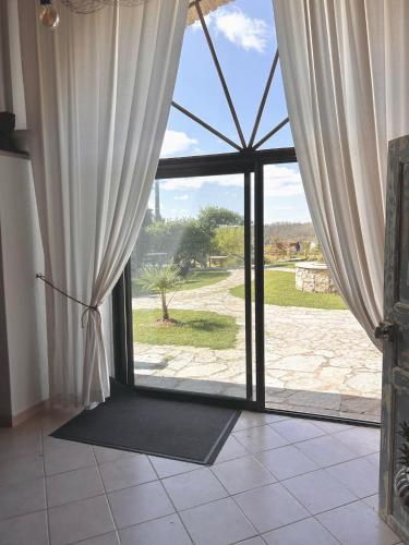 d'une grande porte en verre avec vue sur la cour. dans l'établissement La demeure des poètes gîtes, à Les Cabannes