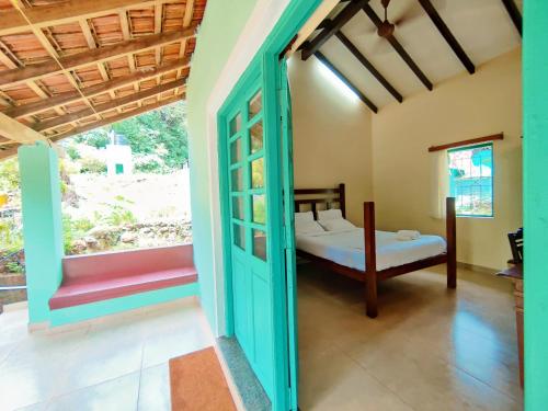 Schlafzimmer mit einem Bett und einem Fenster in der Unterkunft The Bungalow Bogmalo An 1880 Indo Portuguese Heritage Beach Villa South Goa in Bogmalo Beach