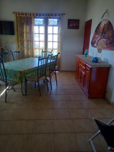 cocina y comedor con mesa y sillas en Mornes Caraïbes en Vieux-Habitants