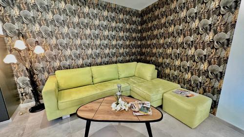 a living room with a green couch and a table at Les Gîtes de la Chapelle 4 in Vauvert