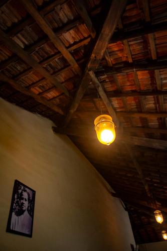 a light on a ceiling with a picture on the wall at The Bungalow Bogmalo An 1880 Indo Portuguese Heritage Beach Villa South Goa in Bogmolo