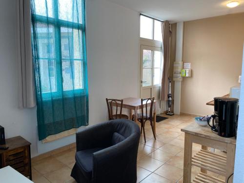 un soggiorno con una sedia e un tavolo di Appartement familial centre et plage a Soulac-sur-Mer
