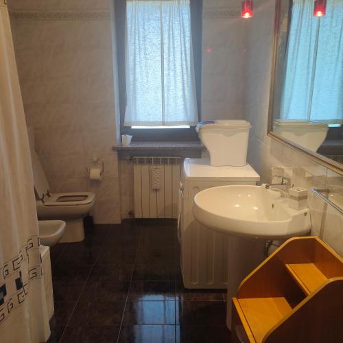 a bathroom with a sink and a toilet and a mirror at Casa Jesus in Almese