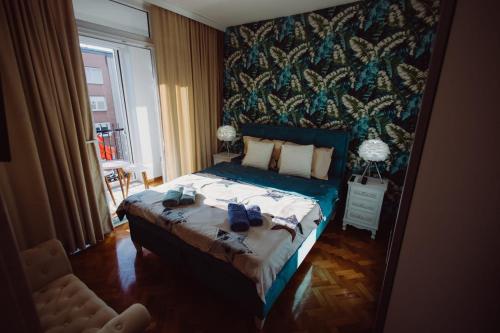 a bedroom with a bed with shoes on it at Apartman Milos, privatan parking in Kraljevo