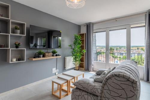 ein Wohnzimmer mit einem Sofa und einem Tisch in der Unterkunft Appartement 1 pièce très chaleureux in Louviers