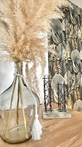 a glass vase with feathers in it on a table at Les Gîtes de la Chapelle 4 in Vauvert