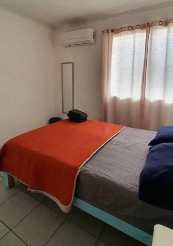 um quarto com uma cama com um cobertor vermelho e branco em Hermoso Departamento Mi Pueblit0 Mágico. em Palenque