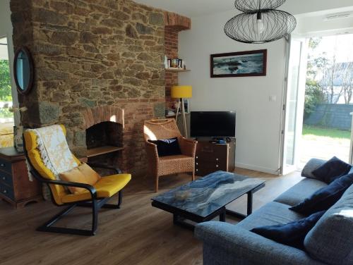 a living room with a couch and a stone fireplace at Maison de Kerangall in Brest