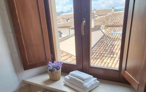 a window with a bunch of towels and a vase with flowers at Antica Dimora San Crisante - centro storico in LʼAquila