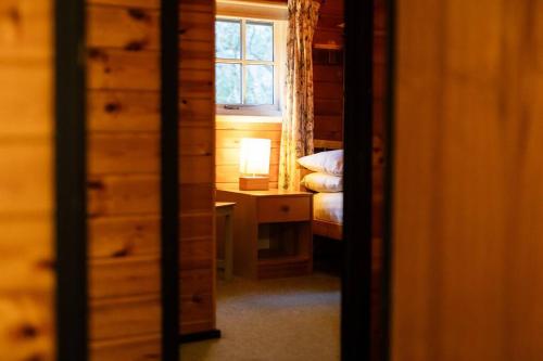 a bedroom with a bed and a desk and a window at Cozy Norwegian Style Log Cabin in Rural Snowdonia - 2 Bedrooms & Parking by Seren Short Stays in Ffestiniog