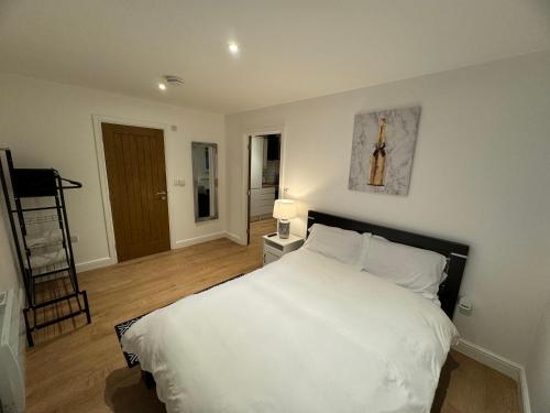 Un dormitorio con una gran cama blanca con una cruz en la pared en LT Apartment 52 - Free Street Parking, en Leicester