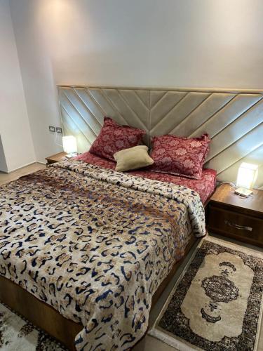 a bedroom with a large bed and two night stands at Résidence palmerie in El Haouach