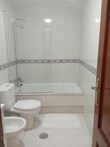 y baño blanco con aseo y bañera. en Apartamento en el casco histórico, en Santiago de Compostela