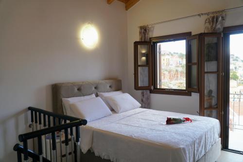 a bedroom with a bed with a red ribbon on it at Oceanis apartment in Symi