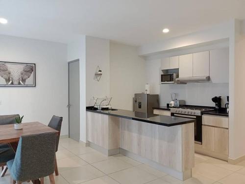- une cuisine avec un comptoir et une table dans une pièce dans l'établissement Federalta Aptm 1 parking/2BR/2BA, à Guadalajara