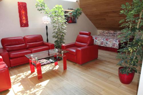 a living room with red furniture and a bed at Kernavės Pajauta in Kernavė