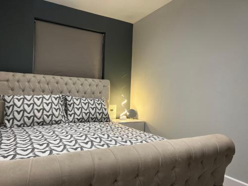 a bedroom with a large bed with a black wall at Broadway Retreat with free parking in Herne Bay