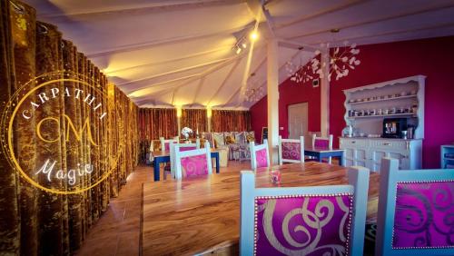 une salle à manger avec une tente, des tables et des chaises dans l'établissement Carpathia Magic, à Peştera