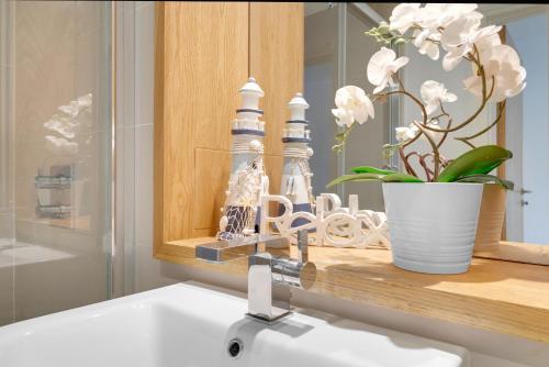 um lavatório de casa de banho com uma torneira ao lado de um espelho em Modern 3 Bed 2 Bath Apartment London Denmark Hill, Camberwell, Brixton - Perfect For Long Stays em Londres