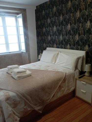 1 dormitorio con 1 cama con toallas en Apartamento en el casco histórico, en Santiago de Compostela
