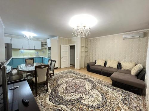 Горький парк Residence في ألماتي: غرفة معيشة مع أريكة وطاولة