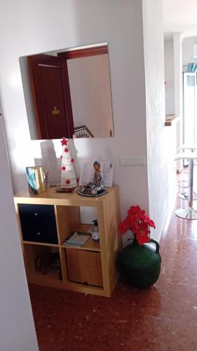 a dresser with a mirror and a vase with flowers at Casa Rural Plaza Zahara Buenas Vistas in Zahara de la Sierra