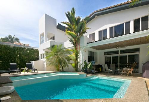 a villa with a swimming pool in front of a house at Luxury Beachfront Oasis - Hermosa Palms 50 in Playa Hermosa