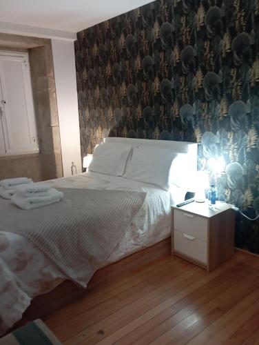 Un dormitorio con una cama grande y una pared con en Apartamento en el casco histórico, en Santiago de Compostela