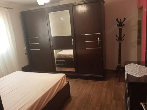 1 dormitorio con un gran armario marrón con espejo en LovelyPlace, en Kigali