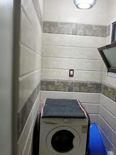 een kleine badkamer met een wasmachine bij LovelyPlace in Kigali