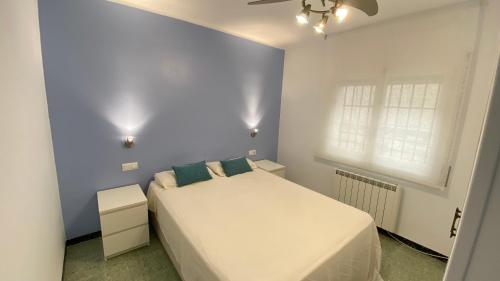 a bedroom with a white bed and a window at Gran sol de la Farella in Llança