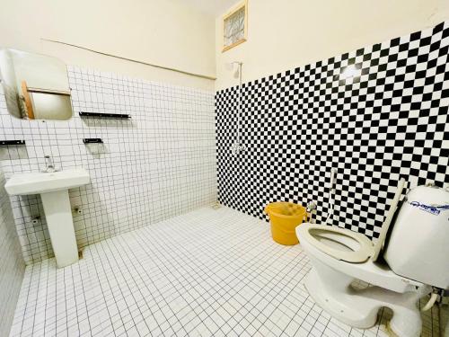 a bathroom with a black and white checkered wall at Airport Hotel Bed & Rest in Karachi