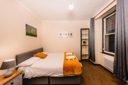 a small bedroom with a bed and a window at Cozy Old Town 4 Bedrm Apartment in Edinburgh