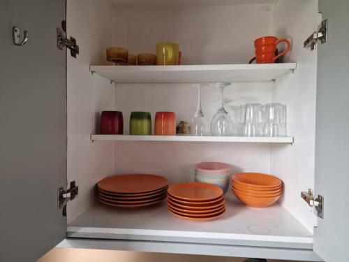 a pantry with plates and bowls on shelves at 22 Stunning Large Loft - Great Location - Free Onsite Parking - Garden View- Quiet in Brighton & Hove