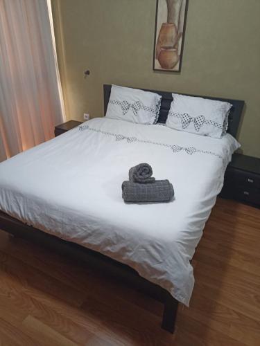 Una cama blanca con una toalla encima. en יולי גולף en Caesarea