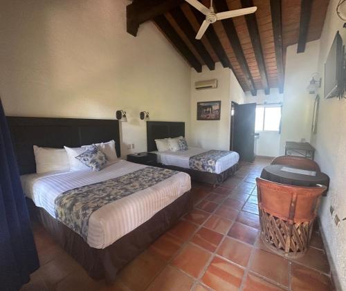 a hotel room with two beds and a ceiling at Hotel Quinta Minera in Cosalá