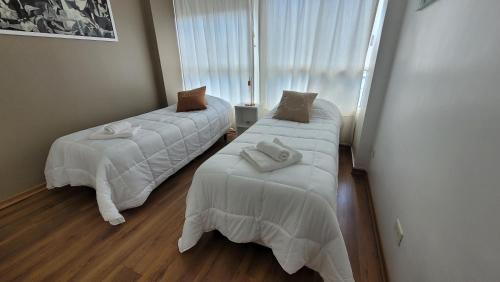 two beds in a hotel room with towels on them at Pampa, Mayo home in Buenos Aires