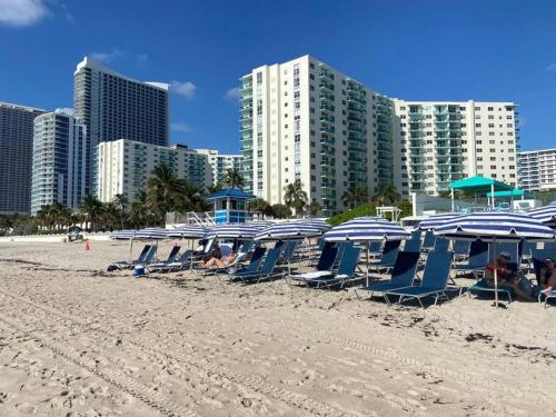 a group of chairs and umbrellas on a beach at Lovely 1 Bedroom & 1 Bath Kitchen Balcony 18 Floor in Hallandale Beach