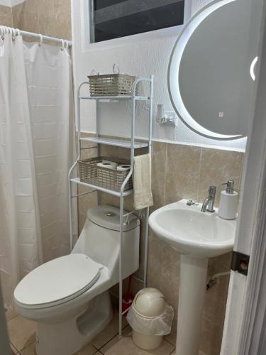 ein Badezimmer mit einem WC, einem Waschbecken und einem Spiegel in der Unterkunft Dream of angels home in Santa Ana