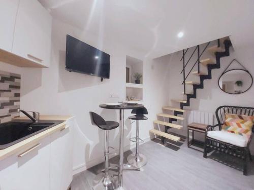 een woonkamer met een tafel en een trap bij Duplex Cosy 1 in Gouesnou