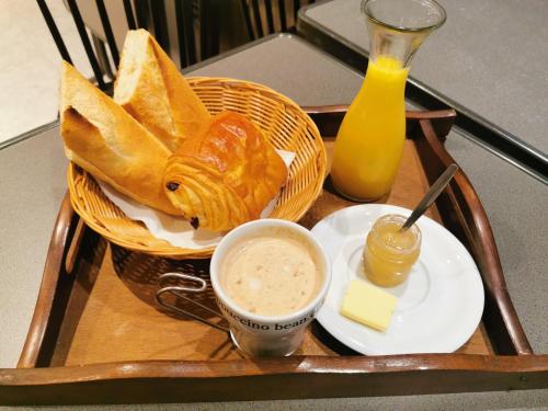 ein Tablett mit einem Teller Brot und einer Tasse Kaffee in der Unterkunft La chambre de pousse in Boulogne-sur-Mer