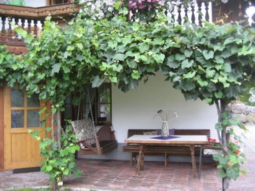 a wooden table and bench under a large tree at Ferienhaus Waidmannsruh in Hippach