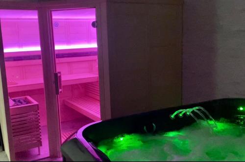 a bathroom with a tub with green and pink lights at VIP Villa & Spa in Colibiţa
