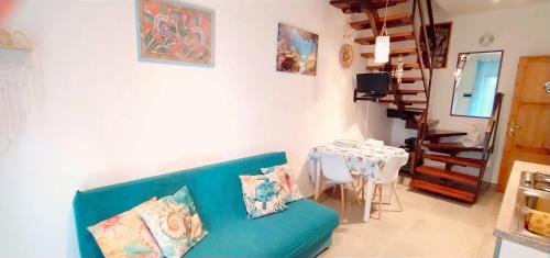 Una sala de estar con un sofá azul y una mesa. en Villa Acquamarina Villasimius, en Villasimius